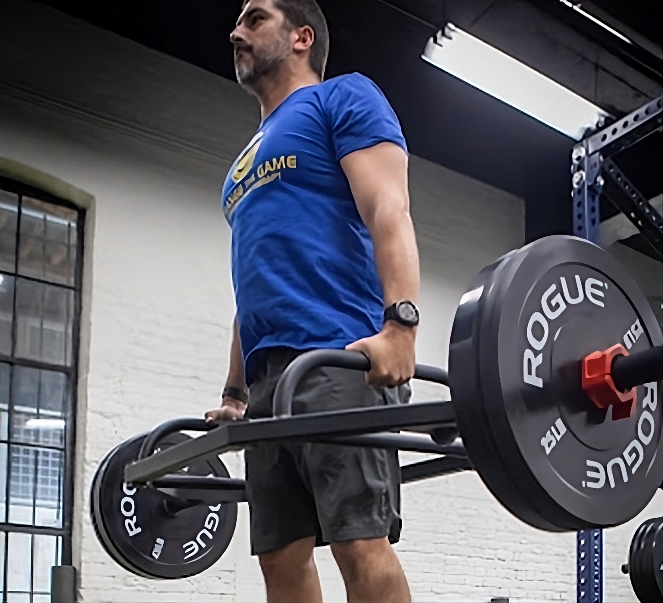 A man lifting a barbell in a gym.