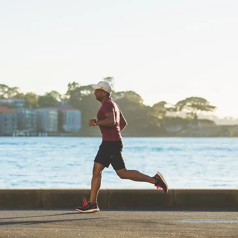 A man jogging by the water in sydney.