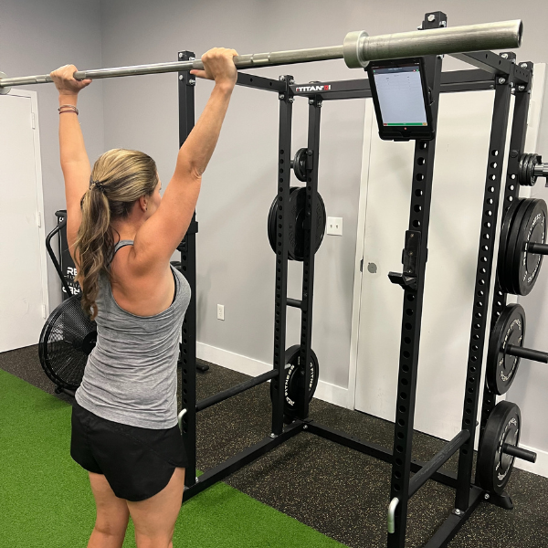 A woman doing a pull up in a gym.